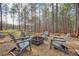 Backyard fire pit area with Adirondack chairs and mature trees provides a relaxing space at 1312 Mcgarity Rd, Temple, GA 30179