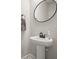 Bathroom with pedestal sink, oval mirror, towel ring, gray walls, and tiled flooring at 1312 Mcgarity Rd, Temple, GA 30179