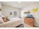 Bright bedroom featuring a comfortable bed, wooden dresser, and playful decor at 1312 Mcgarity Rd, Temple, GA 30179