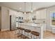 Bright kitchen with stainless steel appliances, white cabinets, granite countertops, island with seating, and wood flooring at 1312 Mcgarity Rd, Temple, GA 30179