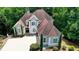 Aerial view of a two-story home with a manicured lawn and mature trees, showcasing its appealing curb appeal at 4580 Lakefield Bend Bnd, Berkeley Lake, GA 30096