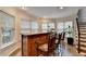 View of the bar area featuring wood cabinets, granite counters, and four bar stools at 4580 Lakefield Bend Bnd, Berkeley Lake, GA 30096