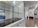 The bar area includes shelves and a black countertop that opens to a living area with hardwood floors at 4580 Lakefield Bend Bnd, Berkeley Lake, GA 30096