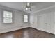 This bedroom features hardwood floors, natural light, a ceiling fan and closet doors at 4580 Lakefield Bend Bnd, Berkeley Lake, GA 30096