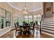 Bright dining nook features a chandelier, large windows, hardwood floors, and access to a deck at 4580 Lakefield Bend Bnd, Berkeley Lake, GA 30096