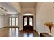 Elegant foyer featuring dark wood flooring, large front door, and abundant natural light through white shuttered windows at 4580 Lakefield Bend Bnd, Berkeley Lake, GA 30096