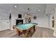 Spacious game room with a pool table, hanging light fixture, fireplace, and neutral decor at 4580 Lakefield Bend Bnd, Berkeley Lake, GA 30096