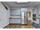 Well-equipped kitchen with stainless steel appliances, gray cabinets, and ample counter space for cooking at 4580 Lakefield Bend Bnd, Berkeley Lake, GA 30096