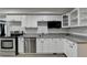 Efficient kitchen features stainless steel appliances, granite countertops and white cabinetry at 4580 Lakefield Bend Bnd, Berkeley Lake, GA 30096