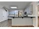 Kitchen features stainless steel appliances, black countertops, skylight, and painted wood cabinets at 4580 Lakefield Bend Bnd, Berkeley Lake, GA 30096