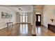 Sun-drenched living room with gleaming hardwood floors, modern light fixture, and an open floor plan at 4580 Lakefield Bend Bnd, Berkeley Lake, GA 30096