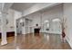 Expansive living room boasting hardwood floors, built-in bookshelves, fireplace and arched windows with plantation shutters at 4580 Lakefield Bend Bnd, Berkeley Lake, GA 30096