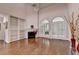 Sunlit living area featuring hardwood floors, fireplace, built-in bookshelves, and arched windows with plantation shutters at 4580 Lakefield Bend Bnd, Berkeley Lake, GA 30096