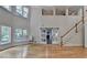 Bright, open living room boasts hardwood floors, and sliding barn doors leading to the fireplace and high ceilings at 4580 Lakefield Bend Bnd, Berkeley Lake, GA 30096