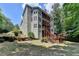 Multi-story home featuring an exterior with multiple decks/balconies overlooking a yard with stairs and trees at 4580 Lakefield Bend Bnd, Berkeley Lake, GA 30096