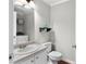 Bright bathroom features a white vanity, matching toilet, and open shelf with decorative vase at 1540 Cedar Bluff Trl, Marietta, GA 30062