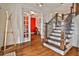 Inviting foyer with hardwood floors, staircase, and glass doors leading to a room with a bold red accent wall at 6510 Nw Long Island Nw Dr, Atlanta, GA 30328