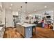 Spacious kitchen with island seating flows into a living area, featuring modern appliances and hardwood floors at 6510 Nw Long Island Nw Dr, Atlanta, GA 30328