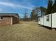 View of a large backyard with storage shed, ample green space, and the brick home exterior at 772 Garner Sw Rd, Lilburn, GA 30047