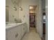 Vanity in bathroom with mirrors and lights, leading to walk-in closet at 772 Garner Sw Rd, Lilburn, GA 30047