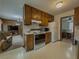 Kitchen featuring wood cabinets, white appliances, and access to a dining area and living room at 772 Garner Sw Rd, Lilburn, GA 30047