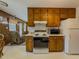 Kitchen view with wood cabinets, white appliances, and a breakfast nook area at 772 Garner Sw Rd, Lilburn, GA 30047