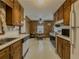 Galley kitchen with wood cabinets, white appliances, open to breakfast nook at 772 Garner Sw Rd, Lilburn, GA 30047