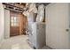 Unfinished basement with utilities, exposed beams, and door to the outside at 1364 Tsali Trl, Morrow, GA 30260