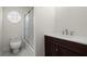 The bathroom has a shower with glass doors, a white toilet and sink, and a dark wooden cabinet at 1364 Tsali Trl, Morrow, GA 30260