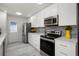Updated kitchen boasts white cabinets, stainless appliances, tile backsplash, and modern countertops at 1364 Tsali Trl, Morrow, GA 30260