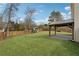 Expansive backyard showcasing a covered patio, play area, and privacy fence at 2815 Chandler Grove Dr, Buford, GA 30519