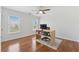 Bedroom featuring hardwood floors, two windows, ceiling fan, and a minimalist workspace at 2815 Chandler Grove Dr, Buford, GA 30519