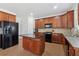 A well-appointed kitchen boasts custom wood cabinetry, black appliances, and a functional island with granite countertops at 2815 Chandler Grove Dr, Buford, GA 30519