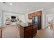 Open-concept kitchen with custom cabinets, a black refrigerator, and a center island flows into the living area at 2815 Chandler Grove Dr, Buford, GA 30519
