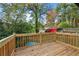 Relaxing back deck showcasing a wooden fence, lush trees, and a shed in a private outdoor space at 2873 Sylvan Rd, East Point, GA 30344