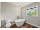 Bathroom featuring a freestanding tub, modern toilet, new vanity, and picture window at 2873 Sylvan Rd, East Point, GA 30344
