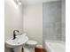 Well-lit bathroom with a pedestal sink, a modern toilet, and tiled shower with a bathtub at 2873 Sylvan Rd, East Point, GA 30344