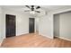 Bedroom featuring neutral walls, wood-look floors, ceiling fan, closet, and two dark wood doors at 2873 Sylvan Rd, East Point, GA 30344