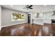 Bright living room featuring hardwood floors, a ceiling fan, and large window overlooking the front yard at 2873 Sylvan Rd, East Point, GA 30344