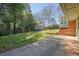 Green backyard with mature trees, a storage shed, and a concrete patio, ideal for outdoor relaxation and activities at 6875 Sunny Brook Ln, Atlanta, GA 30328