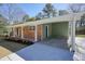 Covered carport attached to the brick home with a green lawn and front porch at 6875 Sunny Brook Ln, Atlanta, GA 30328