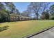Well-manicured front lawn of a brick two-story home with a covered carport and long driveway at 6875 Sunny Brook Ln, Atlanta, GA 30328