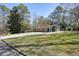 Wide angle view of the front yard, long driveway, carport, and side storage shed at 6875 Sunny Brook Ln, Atlanta, GA 30328