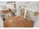 Bright loft area featuring hardwood floors, iron railings, and views of the open-concept living and kitchen space at 6875 Sunny Brook Ln, Atlanta, GA 30328