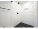 Modern walk-in shower with sleek black and white tiles, black shower head and faucet at 6875 Sunny Brook Ln, Atlanta, GA 30328
