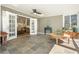 Bright sunroom with slate flooring, plants, a ceiling fan, and double doors leading to the main living area at 6875 Sunny Brook Ln, Atlanta, GA 30328
