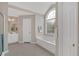 Bathroom with large window over tub, neutral walls and flooring at 1715 Branchwood Ct, Powder Springs, GA 30127