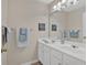 Bathroom featuring dual sink vanity, framed mirror and decorative artwork on the wall at 1715 Branchwood Ct, Powder Springs, GA 30127