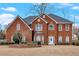 Charming two-story brick home featuring a manicured lawn, mature landscaping, and welcoming front entrance at 1715 Branchwood Ct, Powder Springs, GA 30127