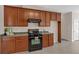 This kitchen features wooden cabinets and is well-lit with a black oven/stove at 1715 Branchwood Ct, Powder Springs, GA 30127